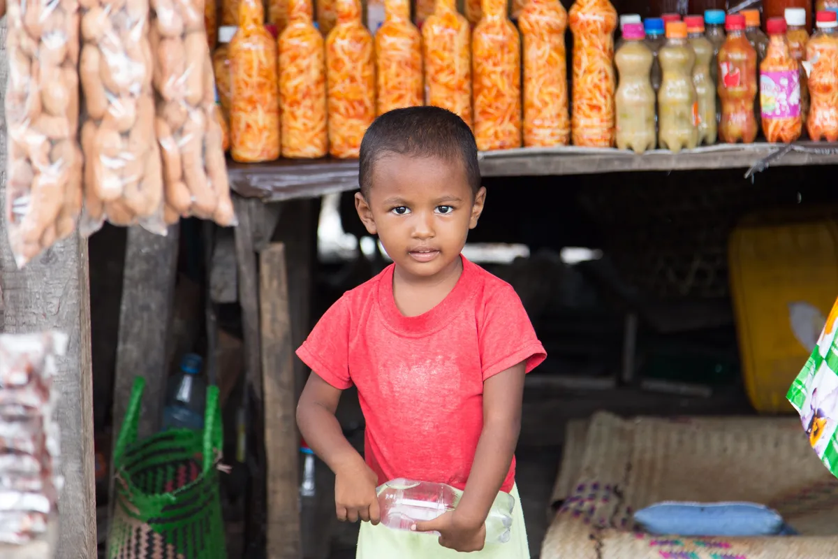 Child in front of a small grocery stall, Madagascar — Nicolas Marincic
