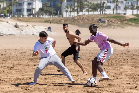 Young men playing football on Ain Diab beach, Casablanca, Morocco — Nicolas Marincic