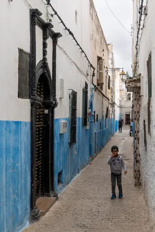 Child in a blue and white alley, Morocco — Nicolas Marincic