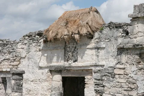 Maya ruin sheltered by a palm-thatched roof, Mexico — Nicolas Marincic