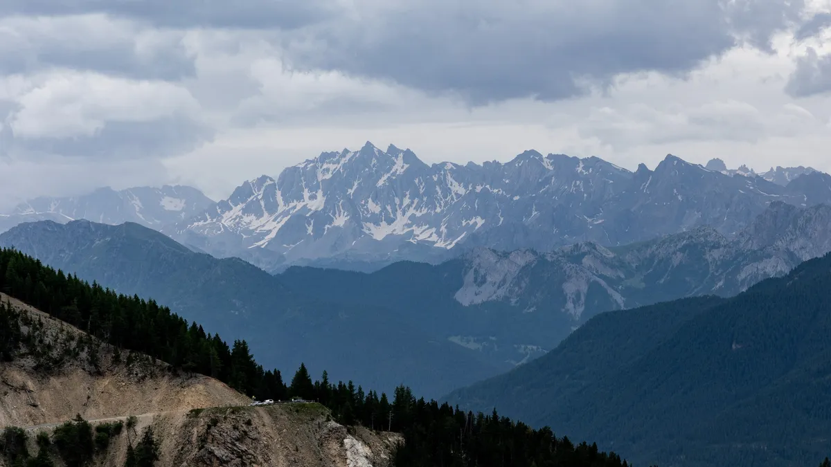 Distant glaciated massif above layered blue ridges — Nicolas Marincic