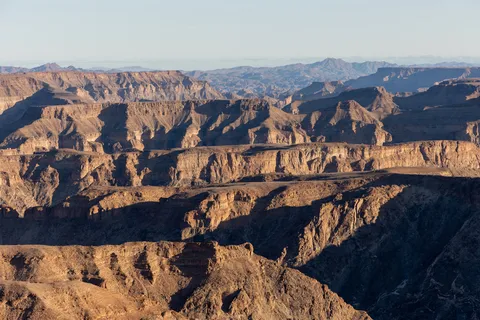 Layered cliffs of Fish River Canyon in late light, Namibia — Nicolas Marincic
