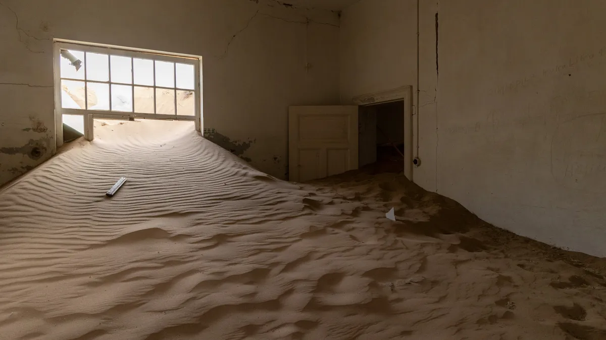 Rippled sand beneath a window, Kolmanskop, Namibia — Nicolas Marincic
