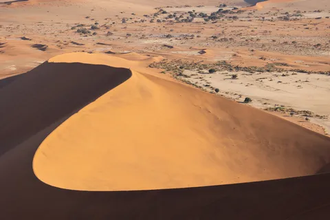 Sweeping dune crescent and deep shadow, Sossusvlei, Namibia — Nicolas Marincic
