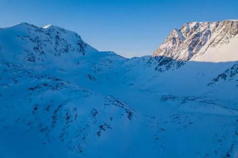 Blue-shadowed snowy peaks from above, Troms, Norway — Nicolas Marincic