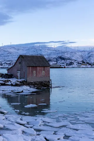 Vieux hangar à bateaux rouge sur pilotis dans la glace, Norvège — Nicolas Marincic