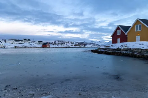Maisons rouge et jaune au bord de la mer gelée, Norvège — Nicolas Marincic