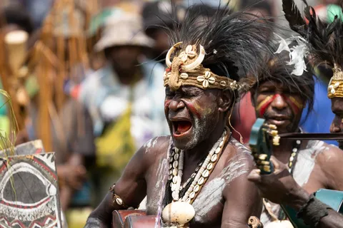 Singer shouting, wearing a shell headband, Papua — Nicolas Marincic
