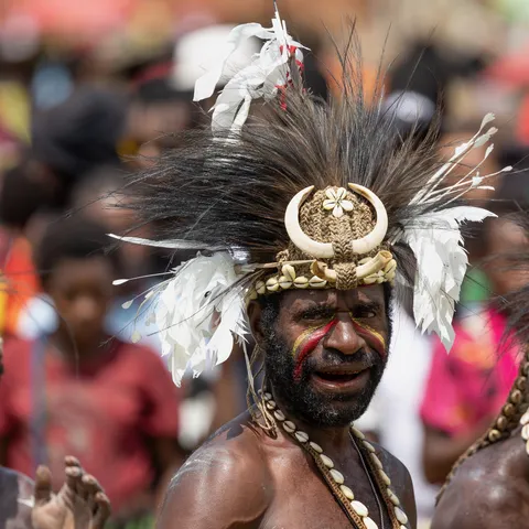Man with boar-tusk and cassowary-feather headdress, Papua — Nicolas Marincic