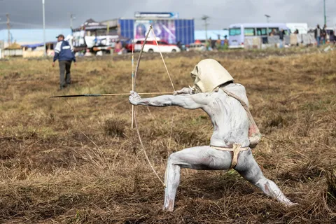Mudman archer drawing his bow, Papua — Nicolas Marincic