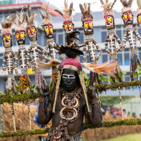 Man before carved figures, Mount Hagen Show, Papua — Nicolas Marincic