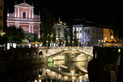 Triple Bridge and Franciscan church reflected in the Ljubljanica, Slovenia — Nicolas Marincic