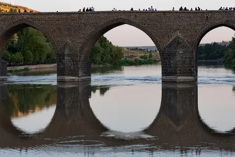 Arches of the Dicle Bridge reflected in the Tigris, Diyarbakır, Turkey — Nicolas Marincic