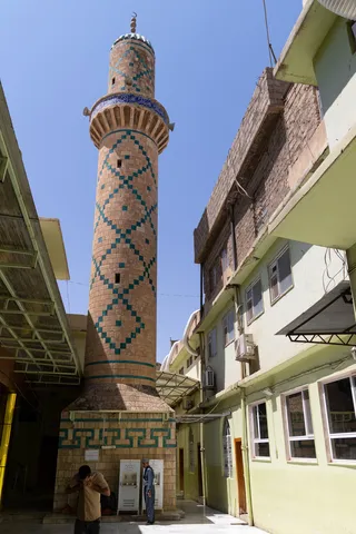 Tiled minaret between buildings, Iraq (Kurdistan) — Nicolas Marincic