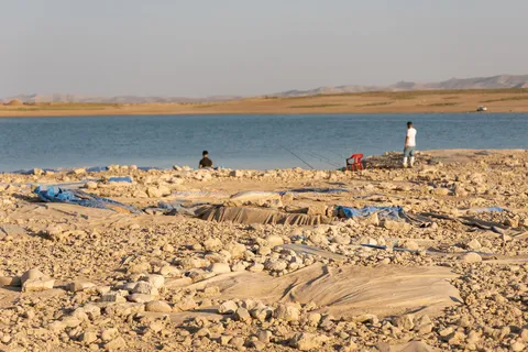 Walkers on the stony shore of a lake, Iraq (Kurdistan) — Nicolas Marincic