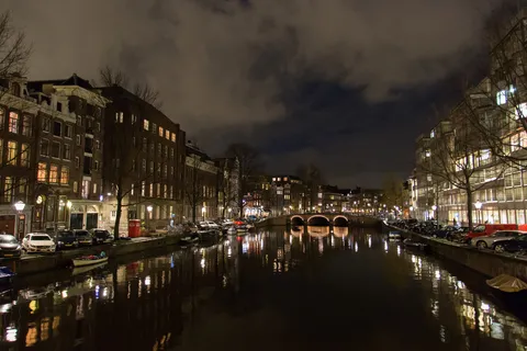 Canal at night under a cloudy sky, Amsterdam, Netherlands — Nicolas Marincic