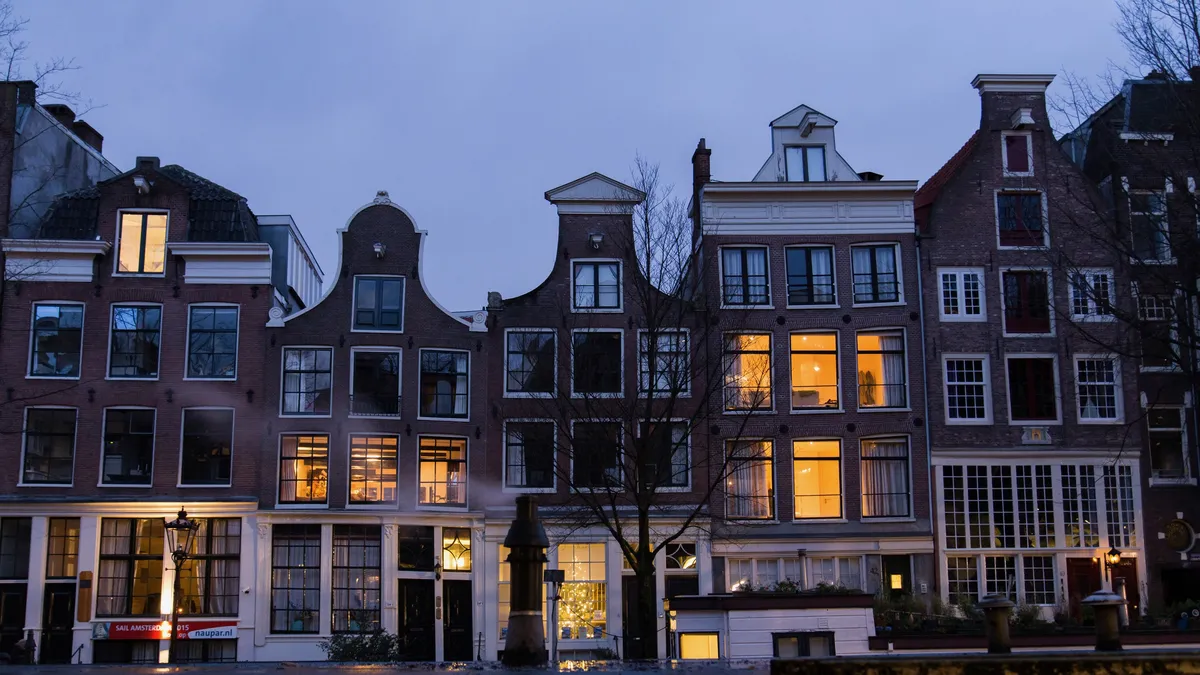 Gabled canal houses lit at blue hour, Amsterdam, Netherlands — Nicolas Marincic