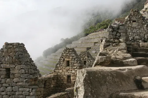 Inca houses and terraces in the mist, Machu Picchu, Peru — Nicolas Marincic