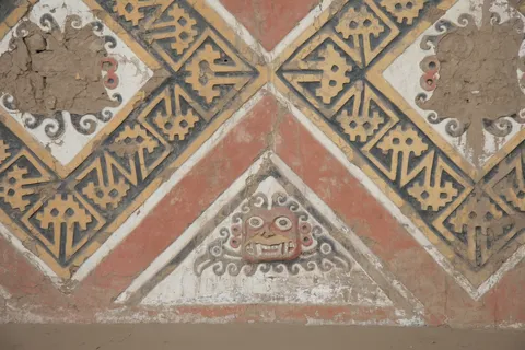 Polychrome reliefs with the face of Ai Apaec, Huaca de la Luna, Peru — Nicolas Marincic