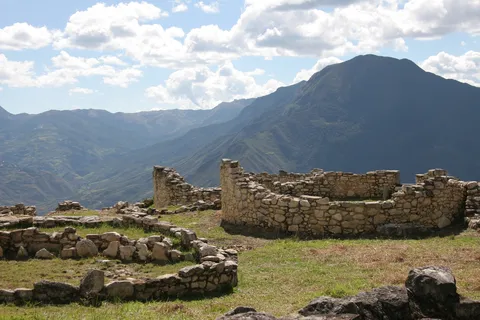 Ruined round houses, mountains and clouds, Kuélap, Peru — Nicolas Marincic