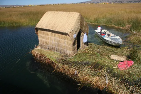 Reed hut and boat on a Uros island, Lake Titicaca, Peru — Nicolas Marincic