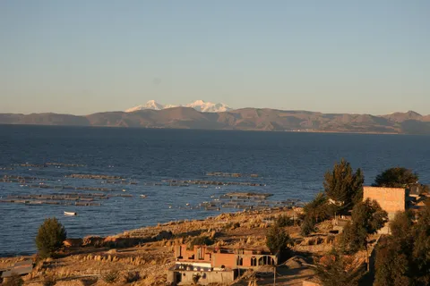 Trout cages and village at sunset, Lake Titicaca, Peru — Nicolas Marincic