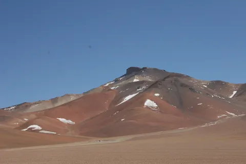 Red snow-streaked volcanic peak, Eduardo Avaroa Reserve, Bolivia — Nicolas Marincic