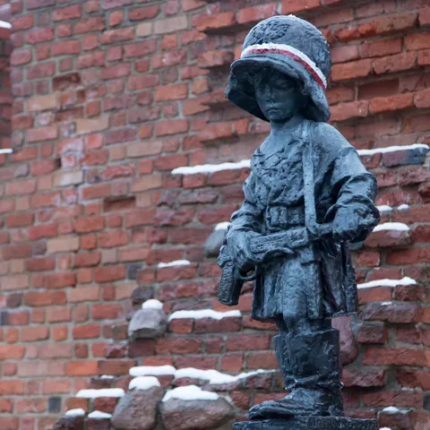 Statue du Petit Insurgé contre un mur enneigé, Varsovie, Pologne — Nicolas Marincic
