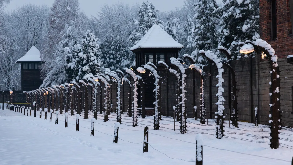Double clôture et mirador sous la neige au crépuscule, Auschwitz I, Pologne — Nicolas Marincic