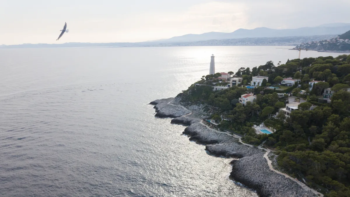 Cap Ferrat lighthouse at sunset, gull in flight, France — Nicolas Marincic