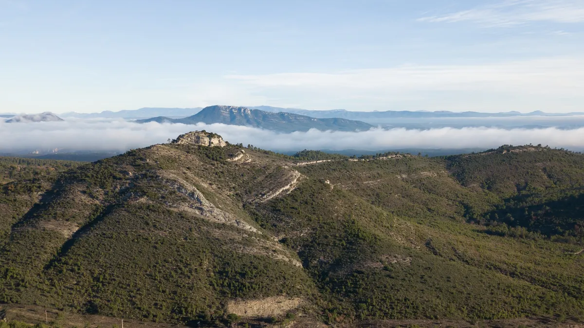 Hilltop chapel above a sea of clouds, France — Nicolas Marincic