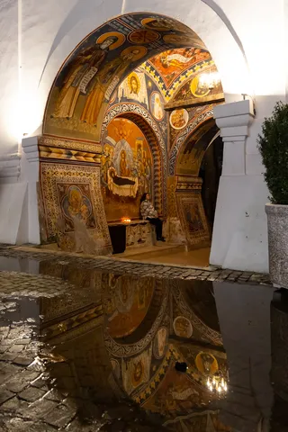 Frescoed church porch reflected in a puddle, Bucharest, Romania — Nicolas Marincic