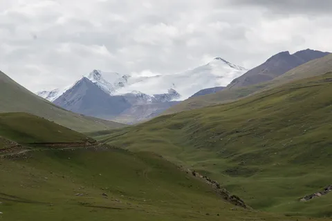 Snowy Tian Shan peaks above green valleys, Kyrgyzstan — Nicolas Marincic