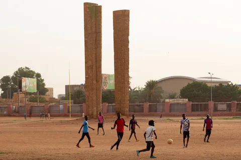 Football match beneath two pillars, Sudan — Nicolas Marincic