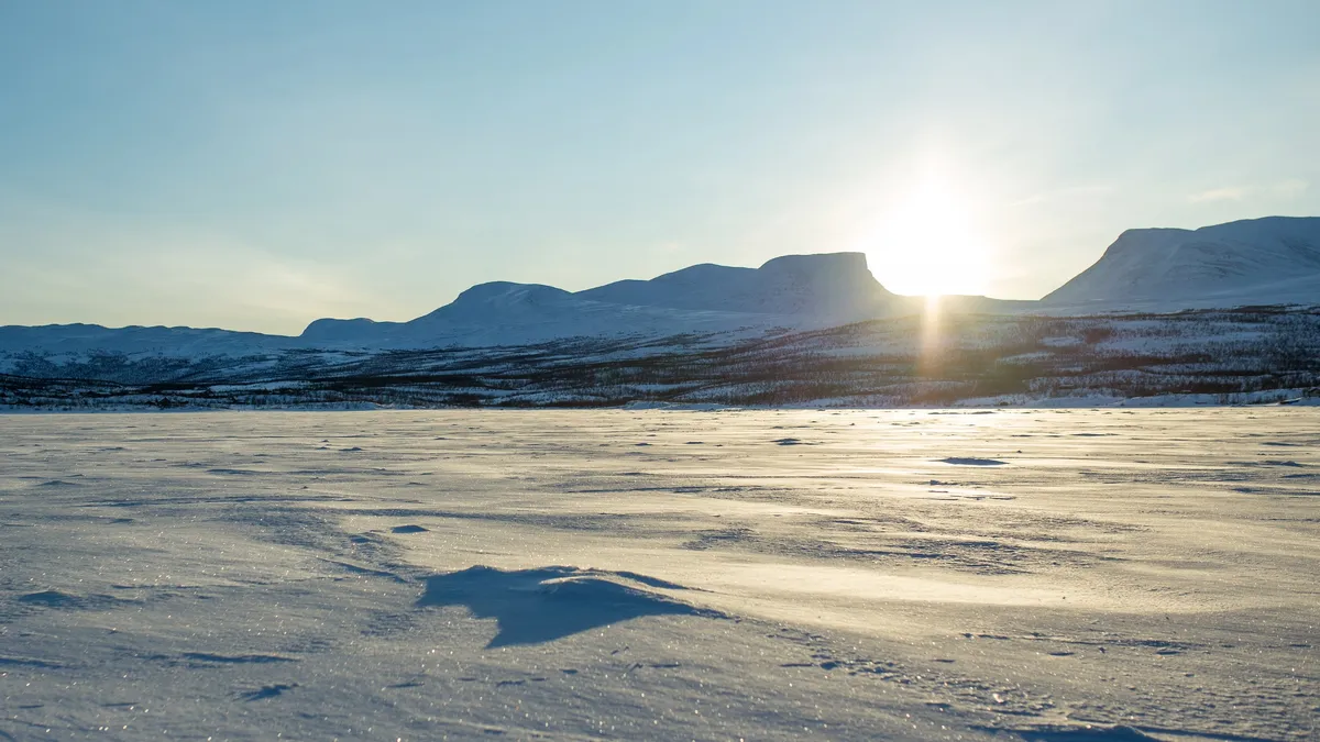 Soleil bas sur un lac gelé, Suède — Nicolas Marincic