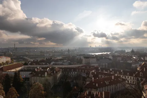 Prague rooftops under clouds and sunbeams from the castle, Czechia — Nicolas Marincic