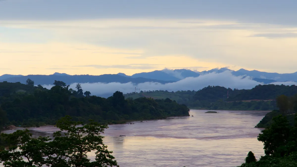 The Mekong at dusk, mist on the Golden Triangle hills, Thailand — Nicolas Marincic