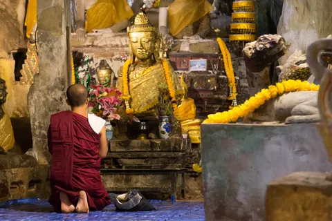 Monk praying before a golden Buddha, Thailand — Nicolas Marincic