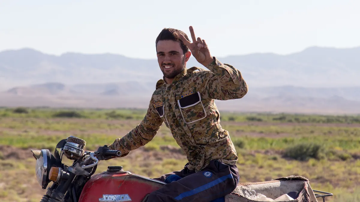 Motard saluant dans la steppe, Turkménistan — Nicolas Marincic