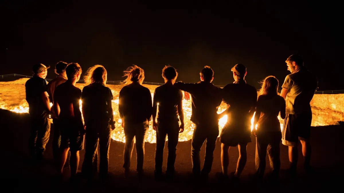 Silhouettes at the rim of the Darvaza crater, Turkmenistan — Nicolas Marincic