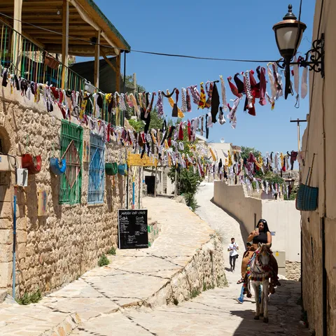 Lane hung with bunting and a rider on a donkey, Turkey — Nicolas Marincic