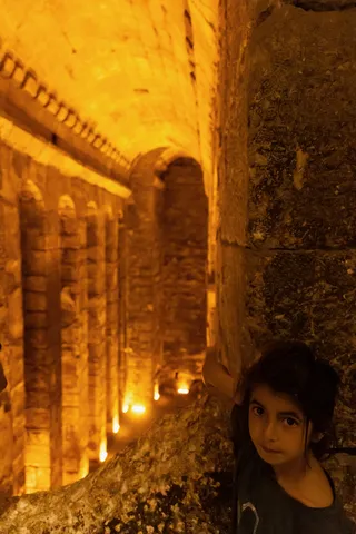 Child in a lamp-lit underground gallery, Turkey — Nicolas Marincic