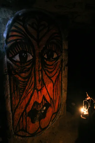 Red-painted tribal face, catacombs, France — Nicolas Marincic