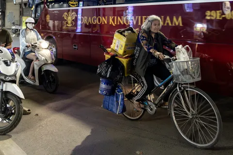 Old woman cycling with loads, Hanoi Old Quarter at night, Vietnam — Nicolas Marincic