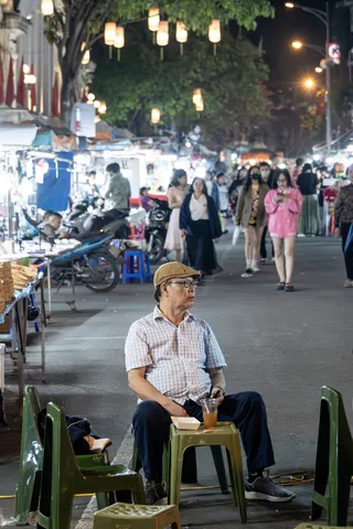 Man seated at the night market, Vietnam — Nicolas Marincic