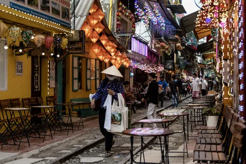 Lantern-lit street lined with café tables, Vietnam — Nicolas Marincic